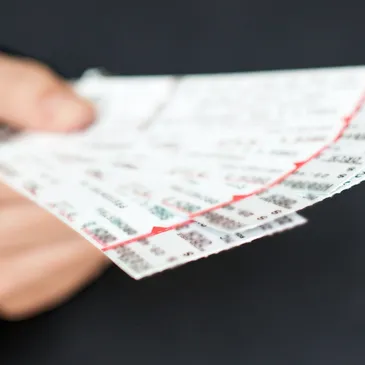 A person holding up tickets to the event.