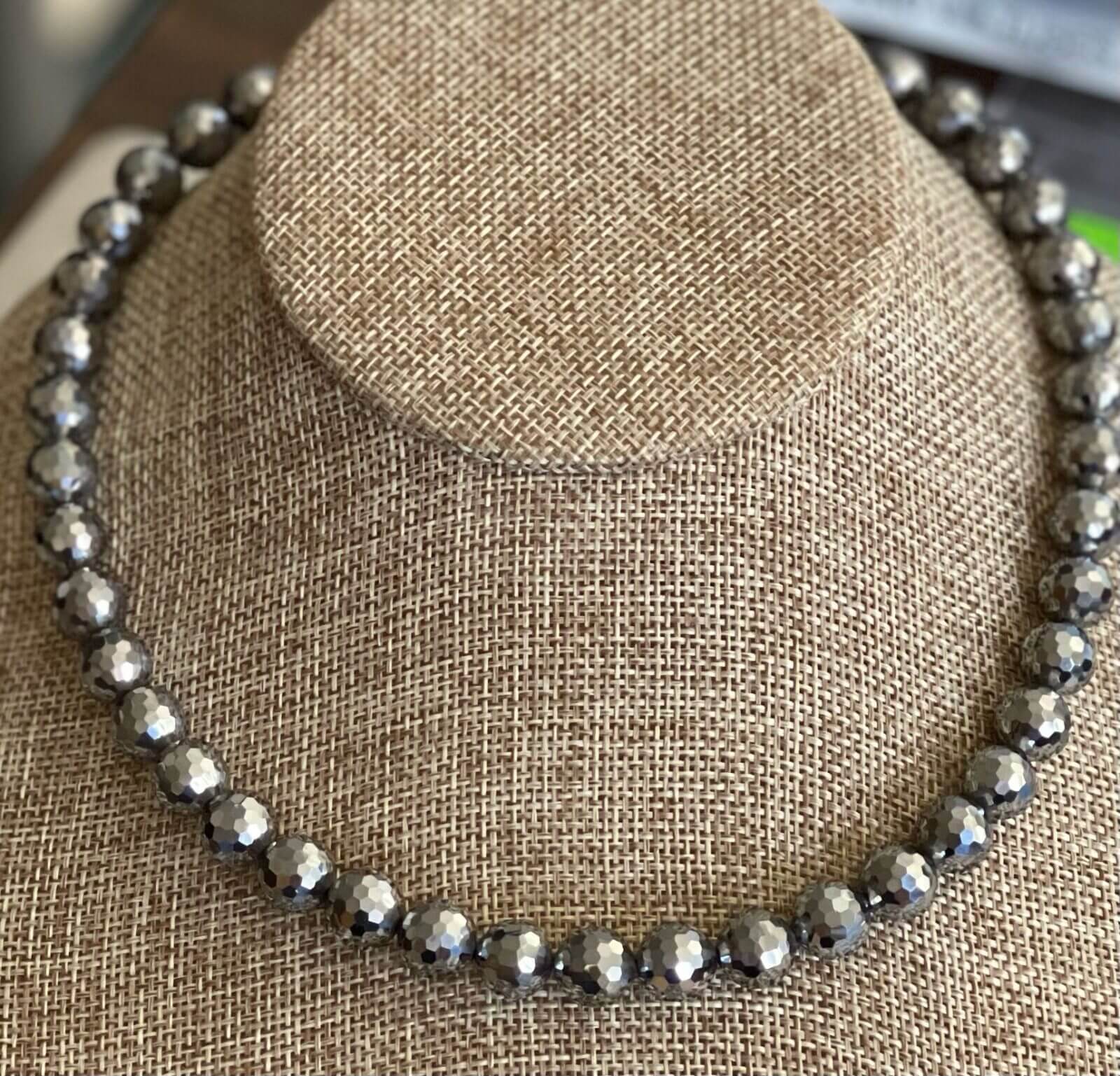 A necklace is shown on top of a hat.