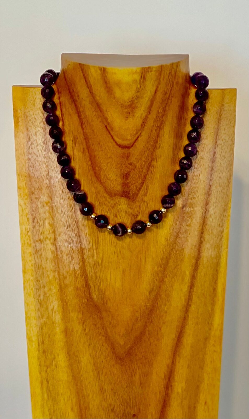 A wooden stand with a necklace on it